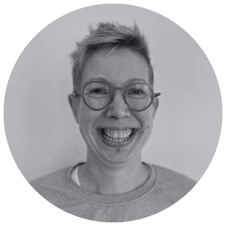 Black and white circular portrait of a person with short hair and glasses, wearing a gray shirt. Sarah Irving - Head of Community and Marketing at Moggie Cat Tracker